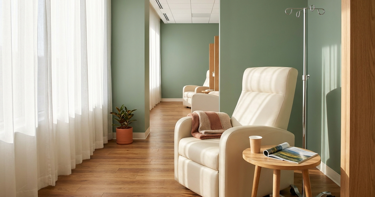 A bright, modern infusion center chair beside a window with natural light, a blanket folded on the armrest, representing the IV induction phase of Omvoh Crohn's disease treatment