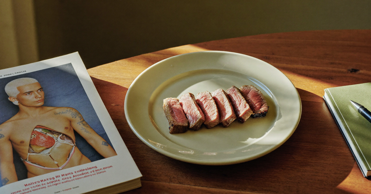 Red meat and Crohn's disease - a plated portion of lean steak beside a research journal and a notebook on a kitchen table