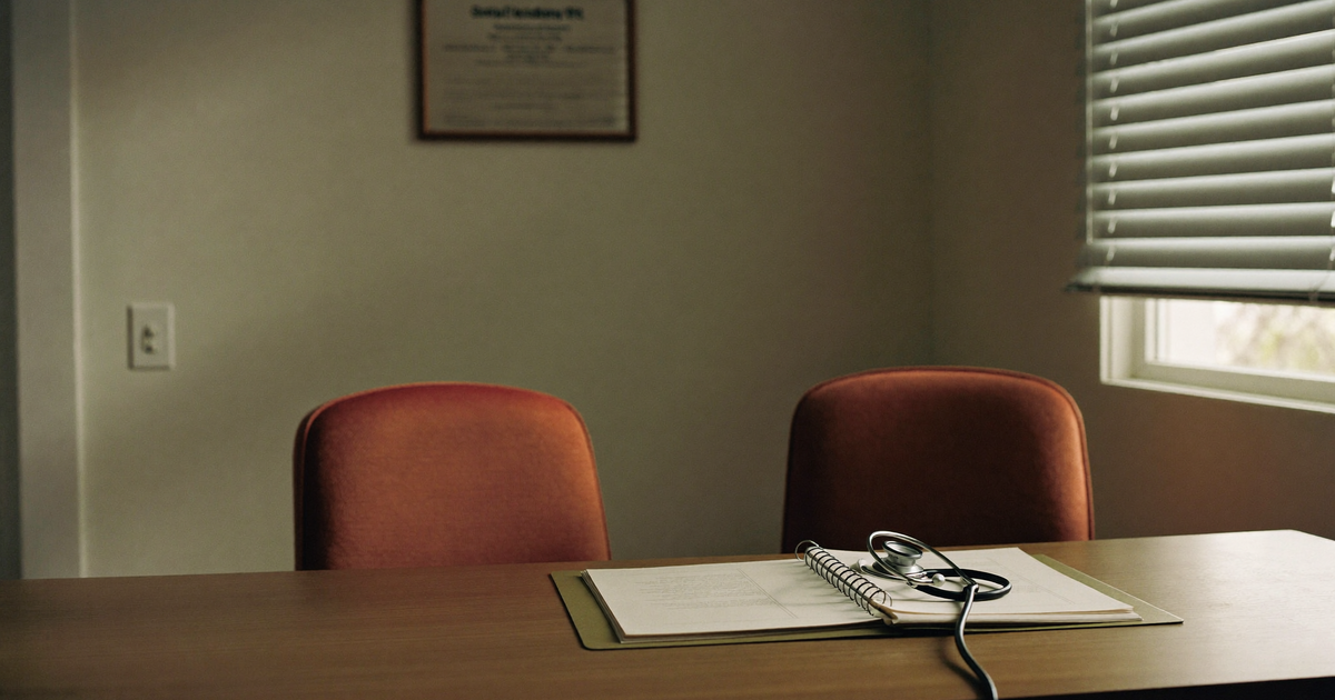Person with Crohn's disease discussing stopping biologics with a gastroenterologist in a clinic room