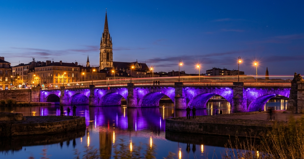 City landmark tower and stone bridge glowing in royal purple light at dusk to mark World IBD Day awareness